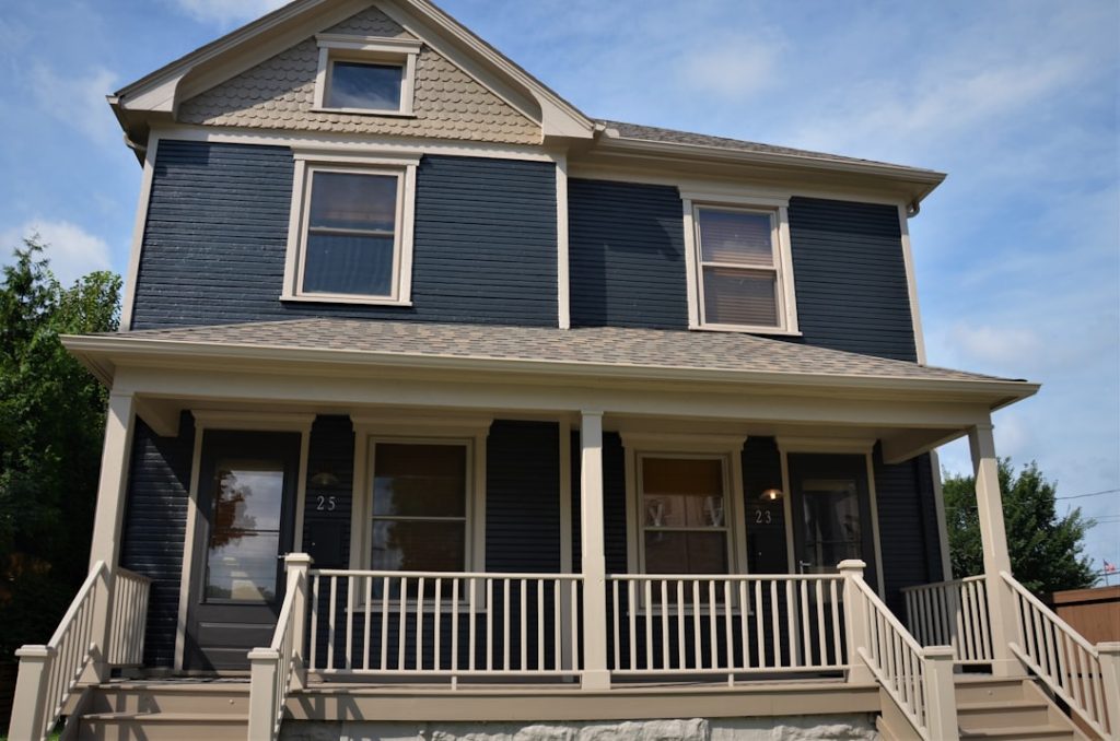 Historic 2 story wooden frame home in blue and white with front porch